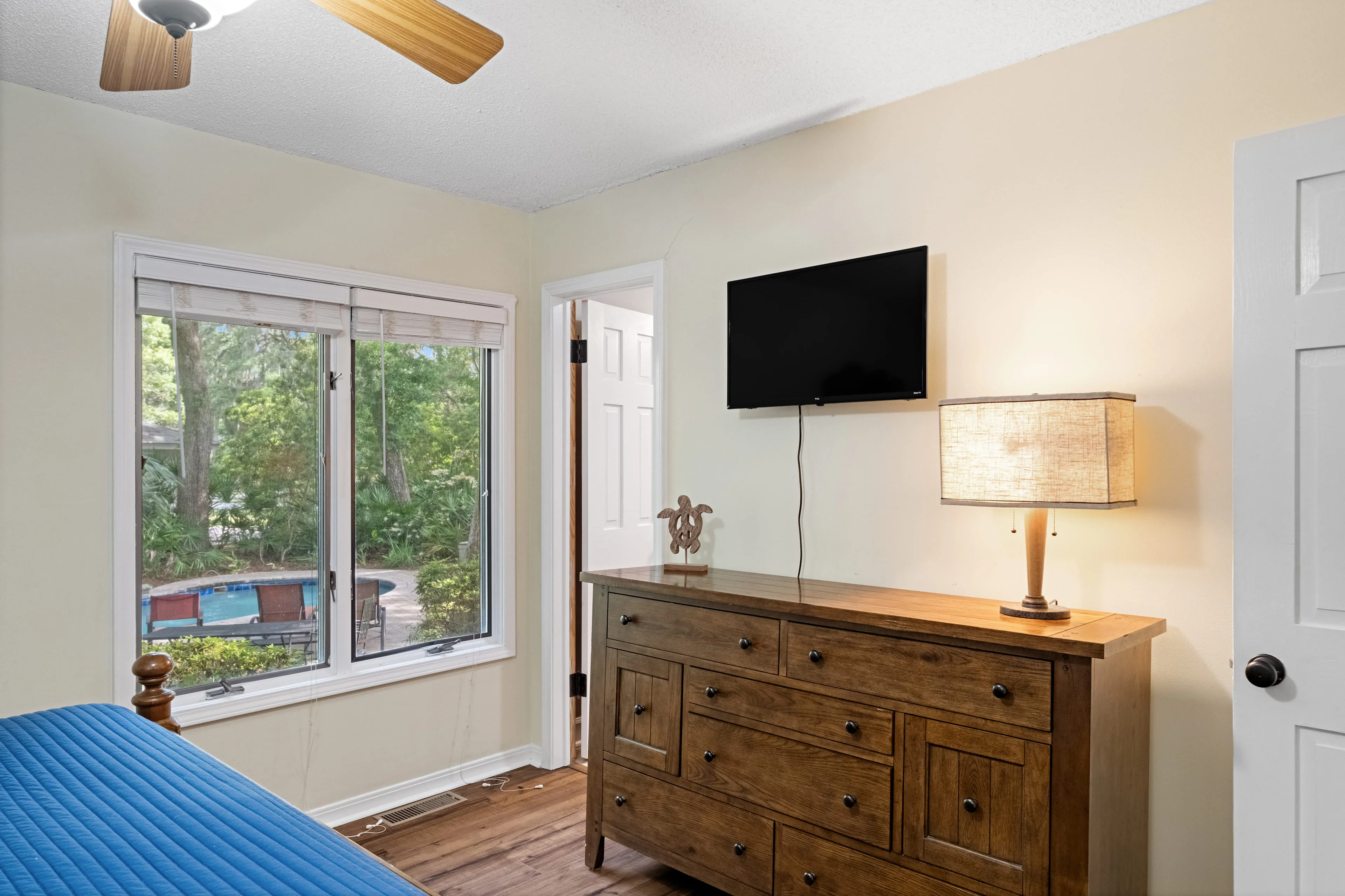Bedroom with ceiling fan and a window view to the pool