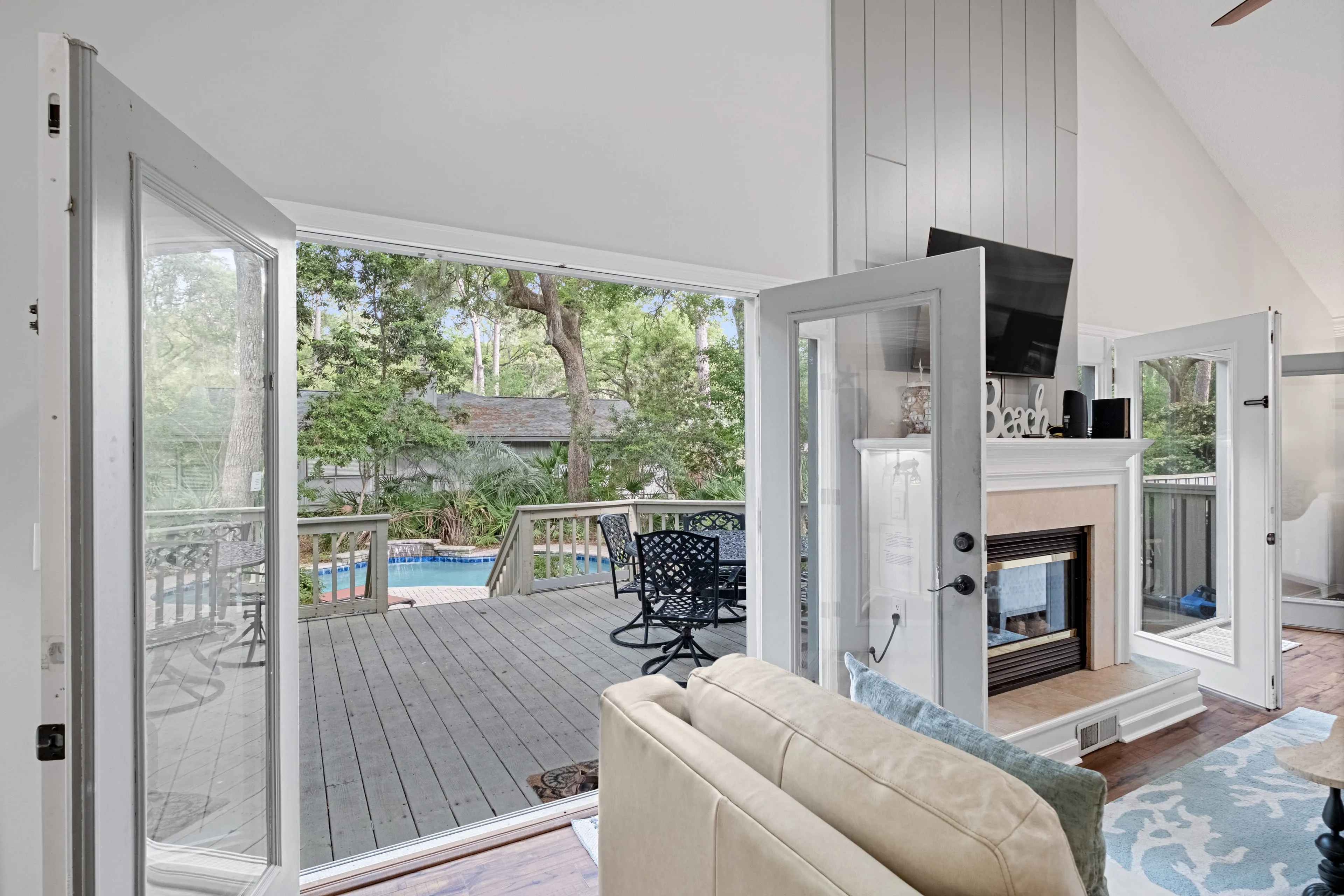 Living room with fireplace and pool view through the doors